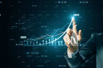Poster - Financial goal and sales targeting concept for 2023 and 2024, with a businessman pressing a button on a virtual forex chart on a digital display hologram, on a dark blue background