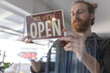 © Wavebreak Media - Happy caucasian male hairdresser turning sign to open on glass door of hair salon