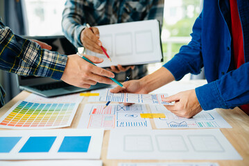  UX developer and ui designer brainstorming about mobile app interface wireframe design with customer breif and color code at modern office..