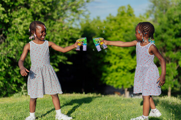 Wall Mural - Two african american girls playing in the park