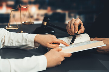 Poster - Closeup lawyer colleagues preparing for lawsuit or litigation, reading and pointing hand on legal book on desk at library for educational law school concept, decorated with legal symbols. Equilibrium