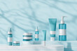 Set of unbranded cosmetic products on geometric platforms. Cosmetics for skin care. Shadows on blue background.