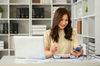 © Prathankarnpap - Young woman financial advisor using smartphone, checking communicating online or consulting client distantly