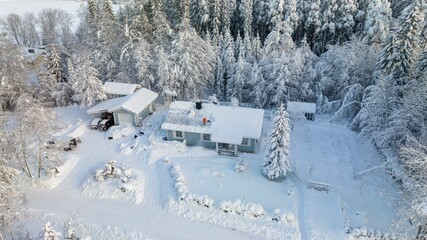 Canvas Print - man removing snow from a house roof with solar panels