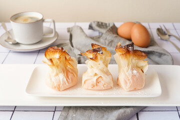 Wall Mural - Traditional Portuguese sweets with egg cream - tulhinhas on the kitchen table served with coffee