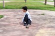 Asian young curly man doing stretching exercise at city park