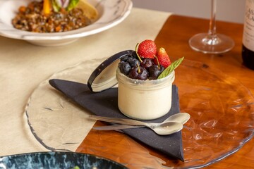 Sticker - Closeup of a cheesecake in a cup with strawberries, cherries and blueberries