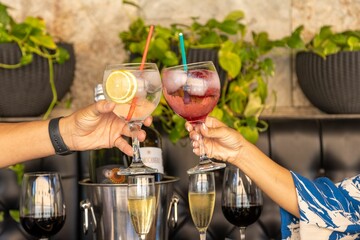 Canvas Print - Caucasian hands cheering with cocktail glasses