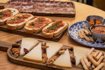 Poster - Closeup shot of wooden boards with bruschettas, slices of bacons and cheese