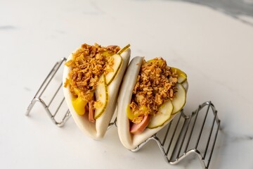 Sticker - Steamed beef bao buns served with fried onions on the marble table