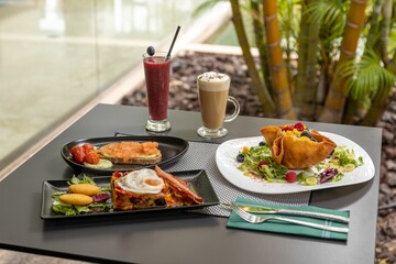 Canvas Print - Closeup of delicious served food and cocktails on a table in a restaurant