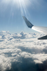 Canvas Print - Wing of airplane flying above clouds