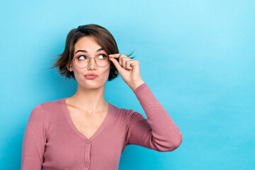 Poster - Photo of doubtful unsure lady wear pink cardigan hand arm spectacles looking empty space isolated blue color background