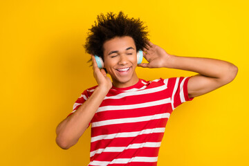 Poster - Photo of excited dreamy guy dressed red t-shirt listening songs earphones isolated yellow color background