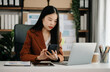 © Nuttapong punna - Business woman using tablet and laptop for doing math finance on an office desk, tax, report, accounting, statistics, and analytical research concept