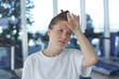 © Евгений Шемякин - Tired exhausted young woman is training workout, running on treadmill in gym holding her head with hand, suffering from headache, feeling unwell, unhealthy during run