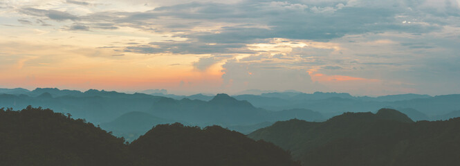 Wall Mural - panorama of sunrise or sunset evening time over the mountains and forest with red or orange clouds s