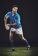 © Duncan M/peopleimages.com - Rugby, passing and man athlete running in dark studio background while training, wellness and fitness sport. Exercise, workout and professional career of sports male person or player on grass