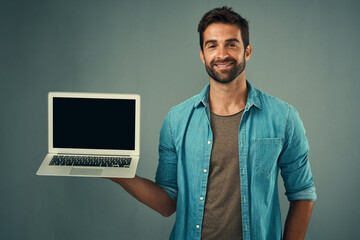 Poster - Happy man, laptop and mockup screen for advertising or marketing against a grey studio background. Portrait of male person with smile showing computer display or mock up space for advertisement