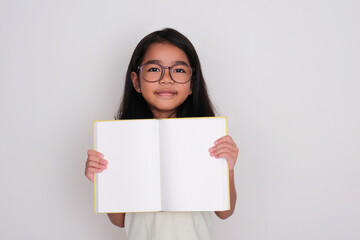Wall Mural - Asian little girl smiling while showing empty book pages