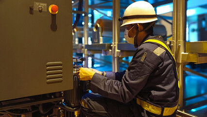 A technician is repairing or maintaining the motor of an industrial machine.