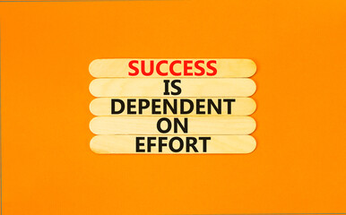 Wall Mural - Success and effort symbol. Concept words Success is dependent on effort on wooden stick. Beautiful orange table orange background. Business success and effort concept. Copy space.