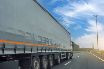 Wall Mural - Truck long tilt curtain side trailer transportation on the road day blue sky.