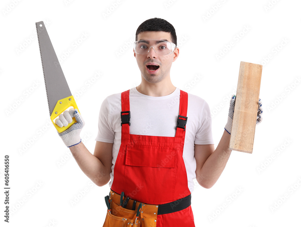 Surprised young carpenter with wooden plank and handsaw on white background