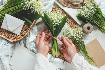 Girl florist holds a bouquet of lilies of the valley in her hands