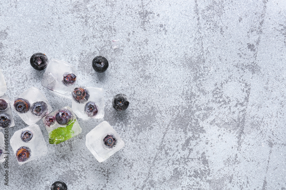 Fresh blueberry frozen in ice cubes on grunge background
