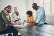 © Flamingo Images - Diverse businesspeople smiling while working around an office table