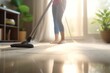 A close-up image of a young maid using a vacuum cleaner to clean a carpet at home.