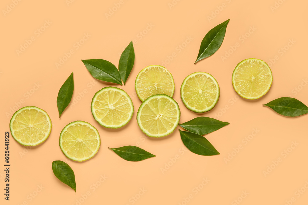 Slices of fresh lime with leaves on orange background