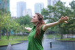 © Евгений Шемякин - Positive young woman smiling during the rain in the park. Cheerful female enjoying the rain outdoors. Woman looking up and catching the rain drop with hands. Breath deep and relax