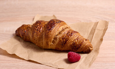 Canvas Print - Baked crispy croissant on a wooden board, breakfast