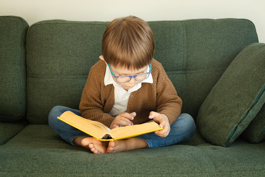 Wall Mural - Little smart boy reads a big book