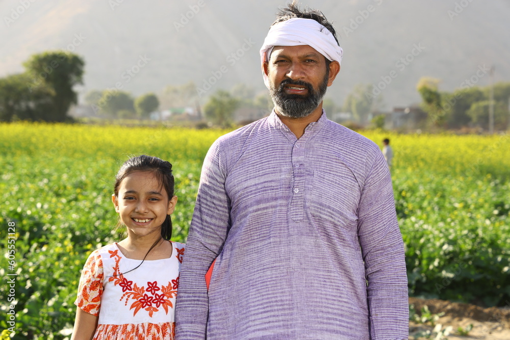 Happy Indian farmer with daughter standing in the mustard field ...