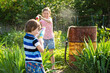 © irena_geo - Two little kids playing with water guns on hot summer day. Cute children having fun with water on the backyard. Funny summer games for kids. Family having water fight outdoors
