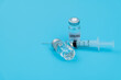 © xy - Syringe and coronavirus vaccine on blue background