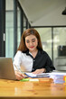 © bongkarn - A businesswoman working on business documents at her desk.
