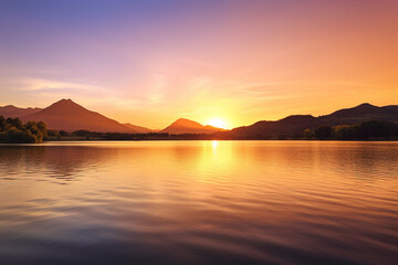 Wall Mural - a beautiful sunset over a lake with mountains in the background