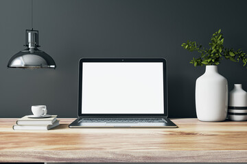 Poster - Front view on blank whit modern laptop screen with space for your web design on wooden work table with vases and books on dark grey wall background with chrome lamp. 3D rendering, mock up