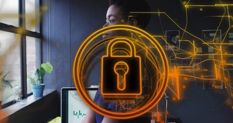 Poster - Animation of security padlock icon over african american woman looking out of window at office