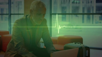 Poster - Animation of heart monitor against caucasian senior businessman using laptop at office