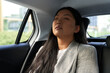 © gpointstudio - Chinese business woman driving in the car as a passenger with eyes closed