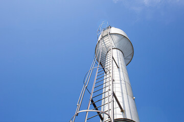 a water tower providing the village with clean drinking water against a blue sky