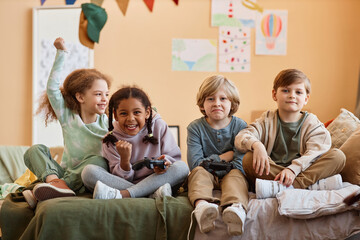 Wall Mural - Portrait of cute black girl winning videogame over boys while playing with friends