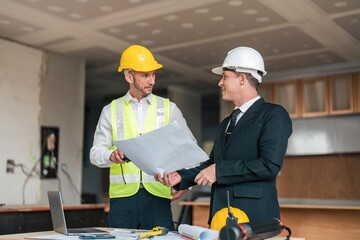 Wall Mural - Professional construction engineers team using blueprint of project plan brainstorming and working together at construction building, Architecture and building construction concept