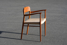 A Danish Mid Century Modern Teak Armchair From The 60s Vintage Standing In The Dining Living Room With Paper Cord Seat Teak Wood 50s 70s Retro Original Isolated Refurbished Outside Sunlight Closeup