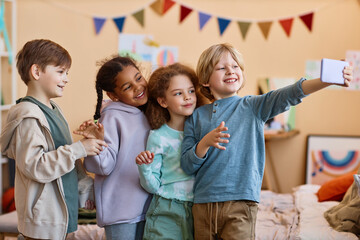 Wall Mural - Diverse group of happy children taking selfie photo together and smiling